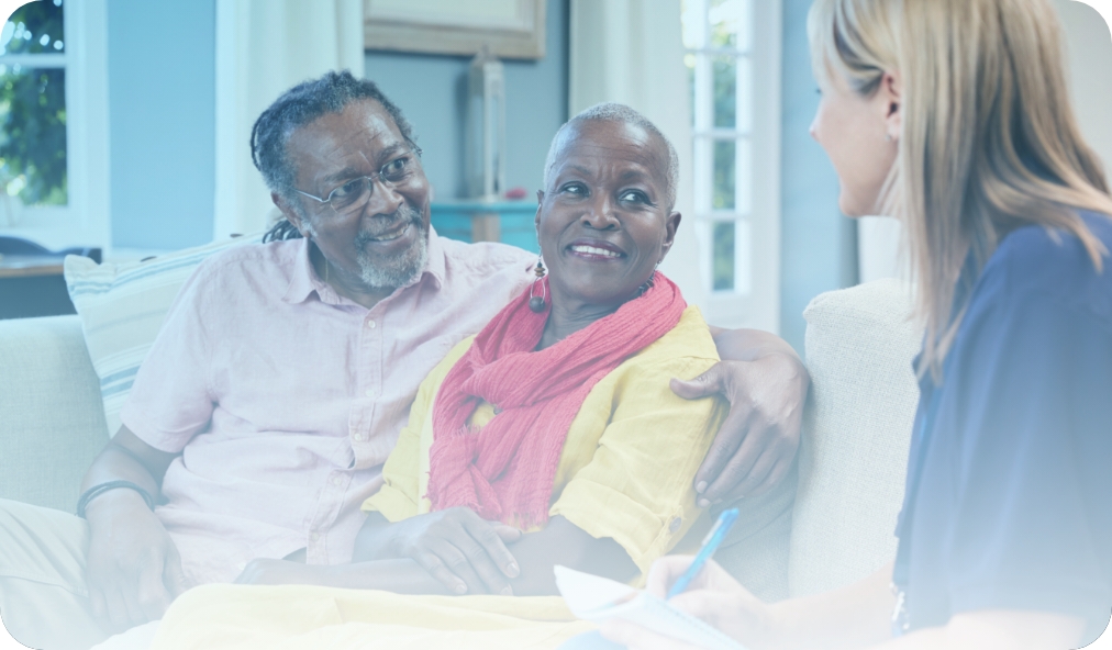 A senior-aged couple having a conversation with a Medicare social worker in their home